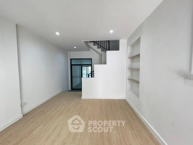 Spacious modern living room with wooden flooring and built-in shelves