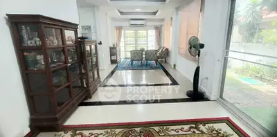 Spacious living room with elegant decor and large windows offering garden views.