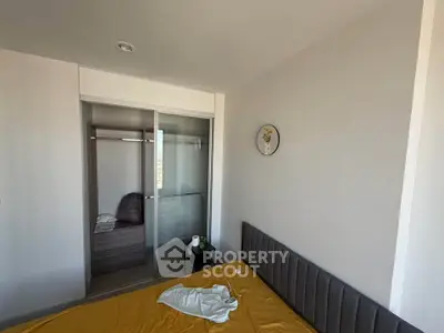 Modern bedroom with sleek design and built-in closet, featuring minimalistic decor.