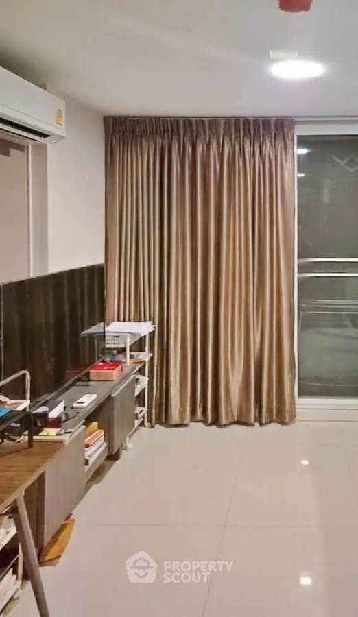 Modern living room with sleek tile flooring and elegant curtains, featuring a compact air conditioning unit.