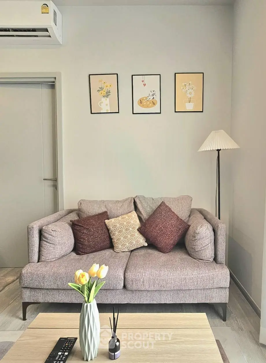 Chic living room with cozy sofa, stylish decor, and modern air conditioning unit.