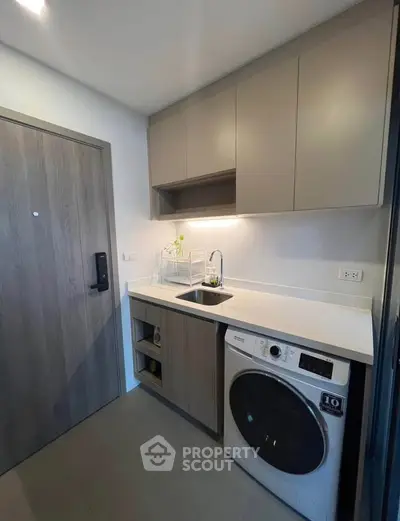Modern kitchen with sleek cabinetry and built-in washing machine