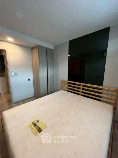 Modern bedroom with wooden bed frame and built-in wardrobe