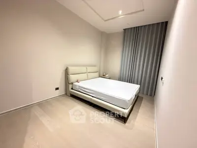 Modern minimalist bedroom with sleek design and neutral tones, featuring a comfortable bed and elegant curtains.