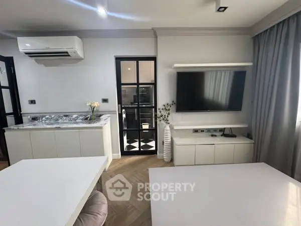 Modern living room with sleek design, featuring a wall-mounted TV and air conditioning unit.