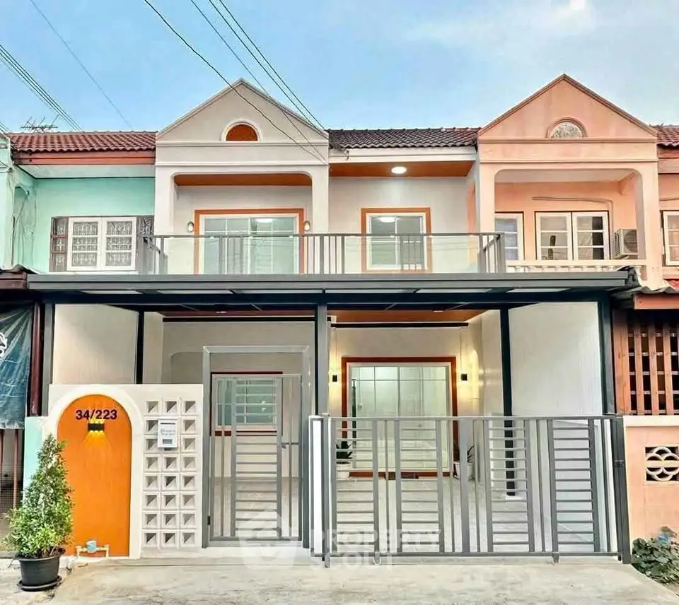 Charming two-story townhouse with modern facade and gated entrance in a vibrant neighborhood.