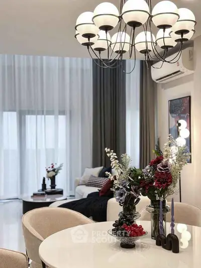 Elegant living room with modern chandelier, stylish decor, and cozy seating area, perfect for relaxation.