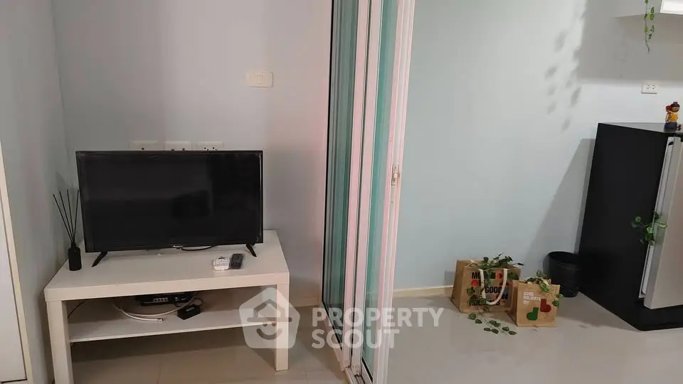 Modern living room with TV and sliding glass door, minimalistic decor