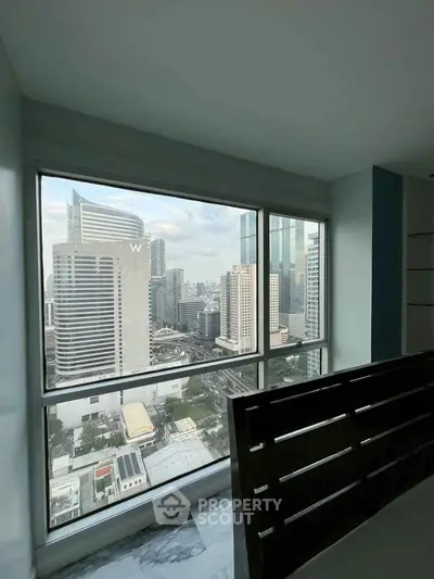 Stunning cityscape view from a high-rise apartment window, showcasing modern urban living.