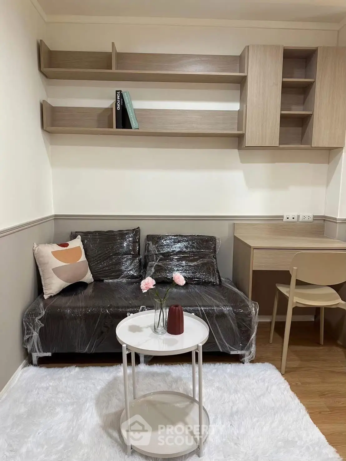 Cozy living room with modern furniture and stylish shelving, perfect for relaxation and productivity.