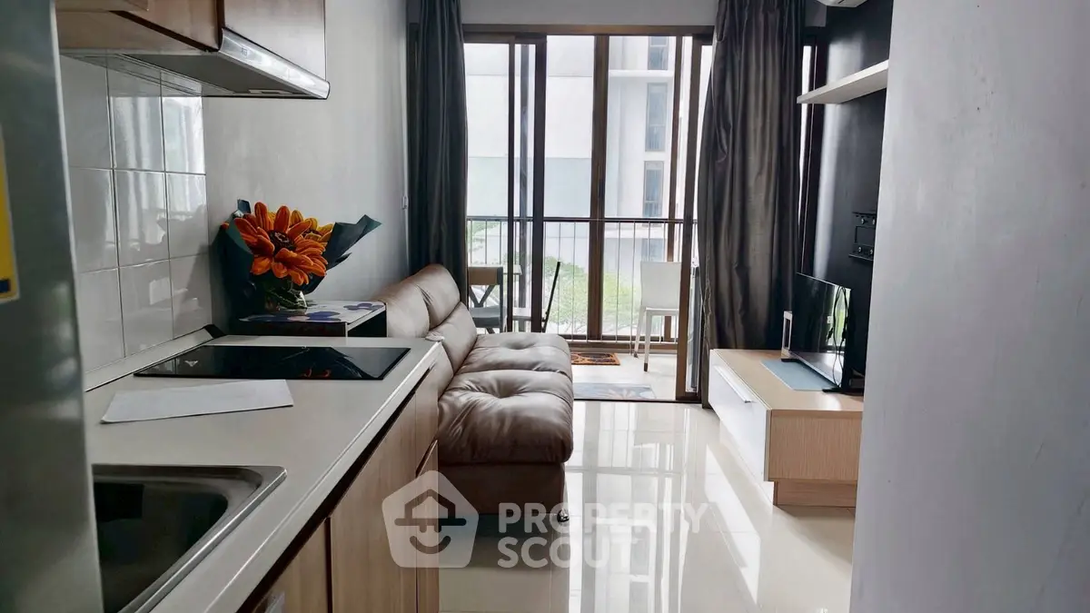 Modern living room with sleek kitchen and balcony view in urban apartment