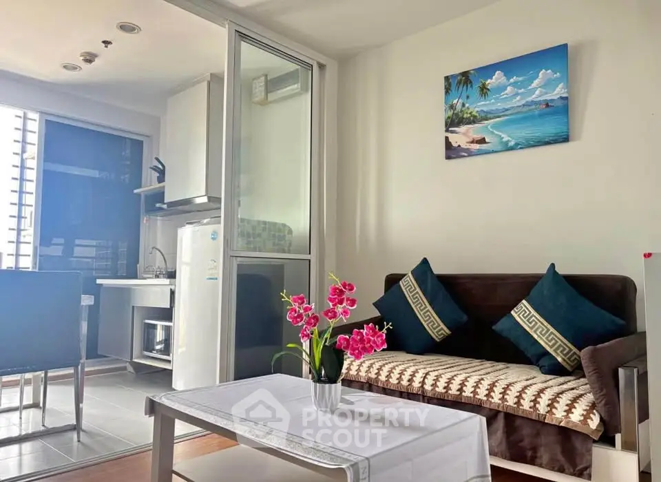 Charming living room with modern decor and kitchenette, perfect for cozy urban living.