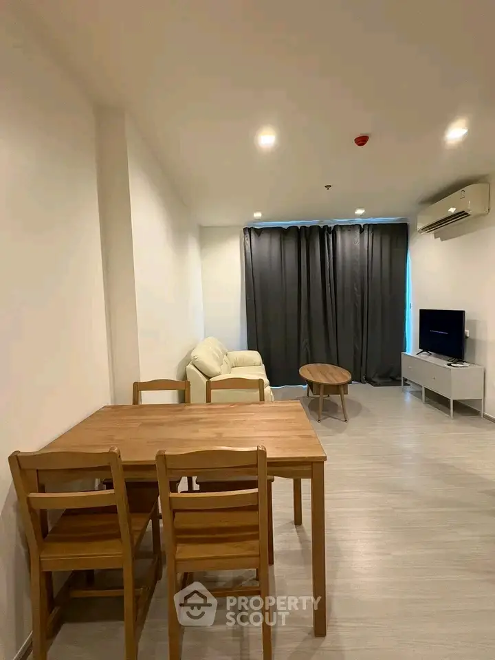 Modern living room with wooden dining set and cozy seating area, perfect for relaxation.