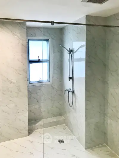 Elegant marble bathroom with glass shower enclosure and modern fixtures