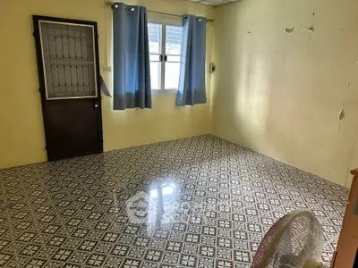 Spacious room with patterned tile flooring and natural light, ideal for versatile use.