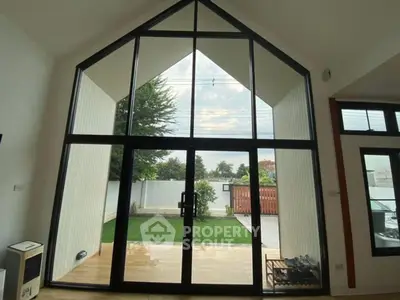 Stunning modern living room with large glass doors opening to a lush garden view.