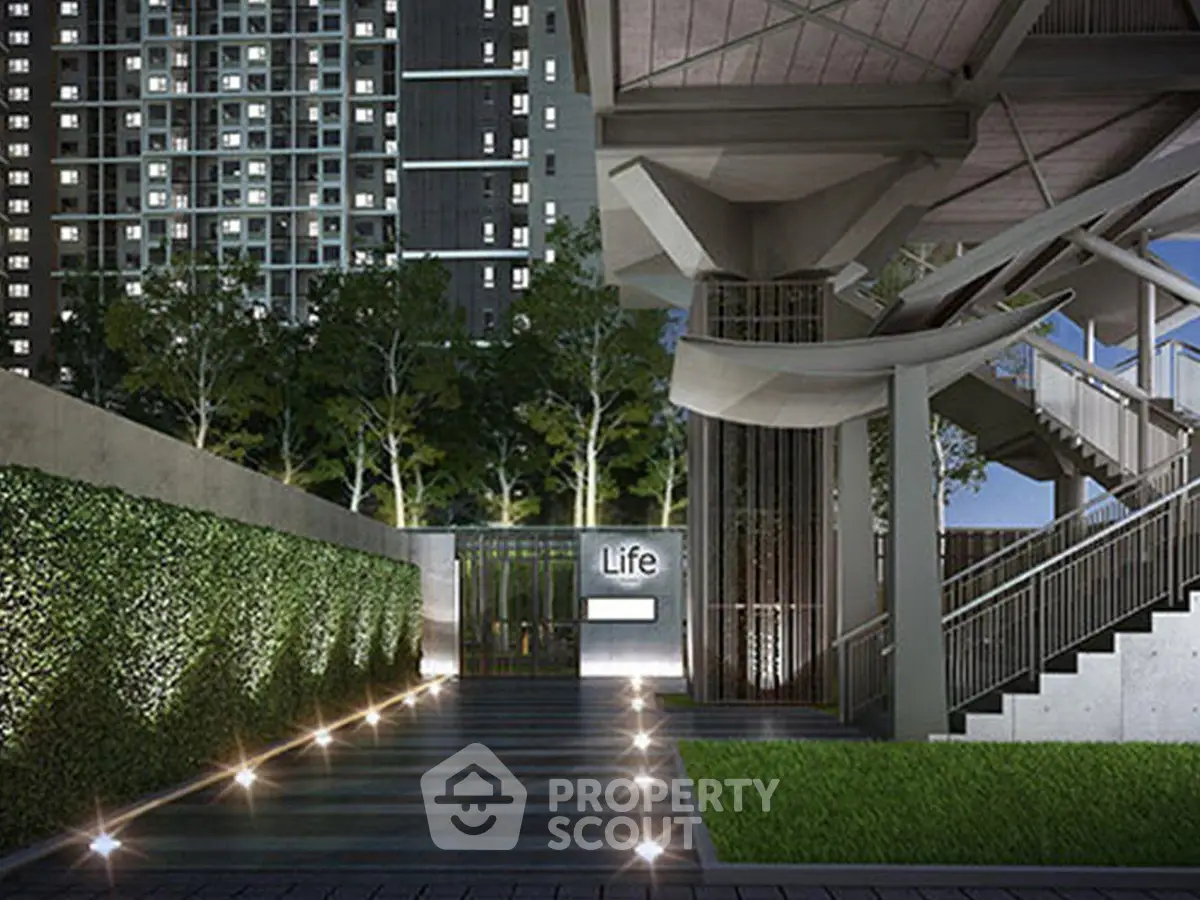 Modern building entrance with sleek design and lush greenery, ideal for urban living.