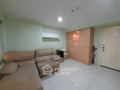 Cozy living room with beige sofa and modern shelving in a stylish apartment.