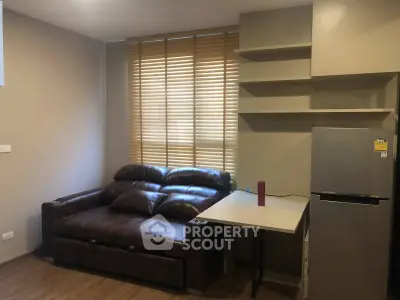 Cozy living room with leather sofa and modern fridge, perfect for urban living.