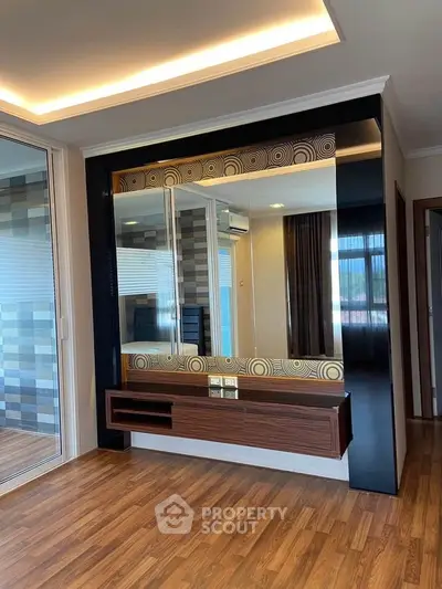 Modern living room with stylish wooden flooring and elegant wall mirror design.