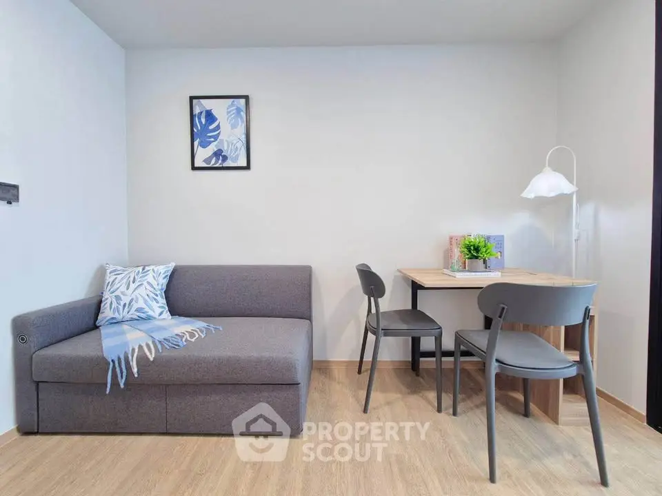 Modern living room with stylish sofa and dining area, featuring minimalist decor and cozy ambiance.