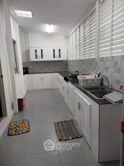 Spacious kitchen with modern cabinets and ample counter space, perfect for culinary enthusiasts.