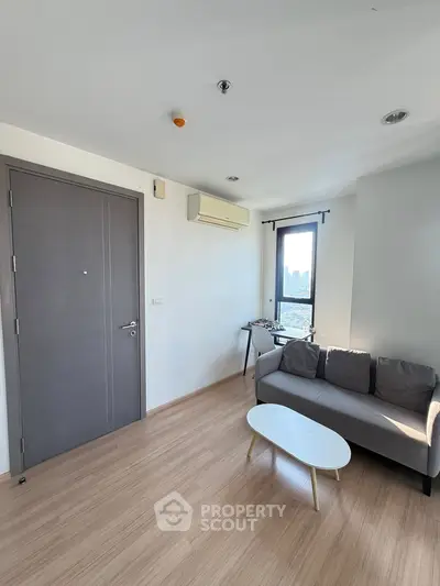 Modern living room with city view, featuring sleek sofa and minimalist decor.