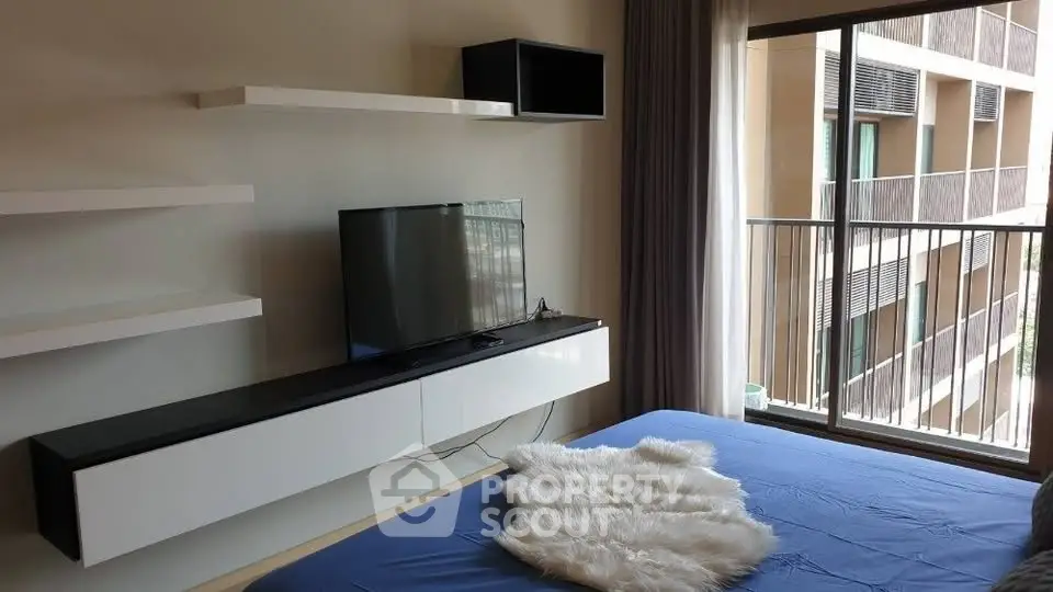 Modern bedroom with balcony view and sleek TV setup