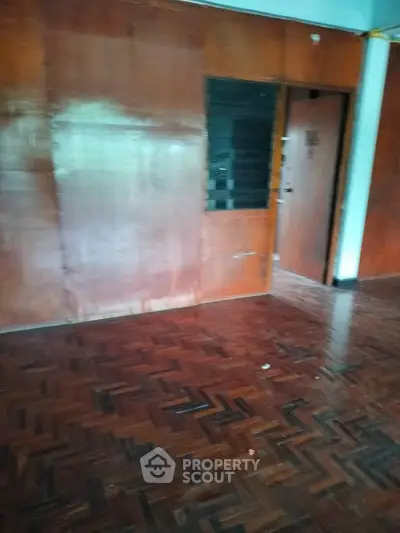 Spacious room with wooden flooring and wall paneling, ideal for customization.