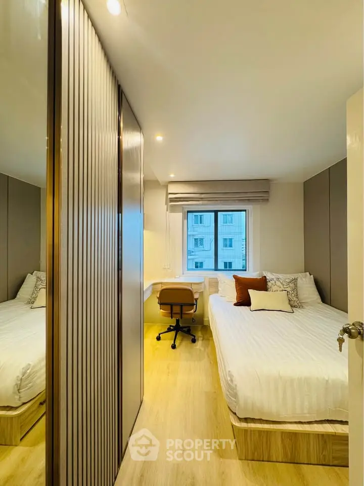 Cozy bedroom with modern decor and study area, perfect for urban living.