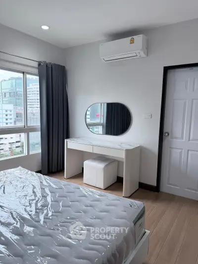 Modern bedroom with city view, featuring a sleek vanity and air conditioning.