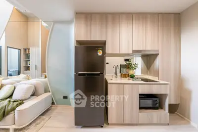 Modern open kitchen with sleek appliances and cozy living area, perfect for urban living.