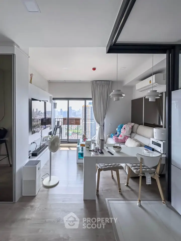 Modern living room with city view, stylish decor, and open layout in high-rise apartment.