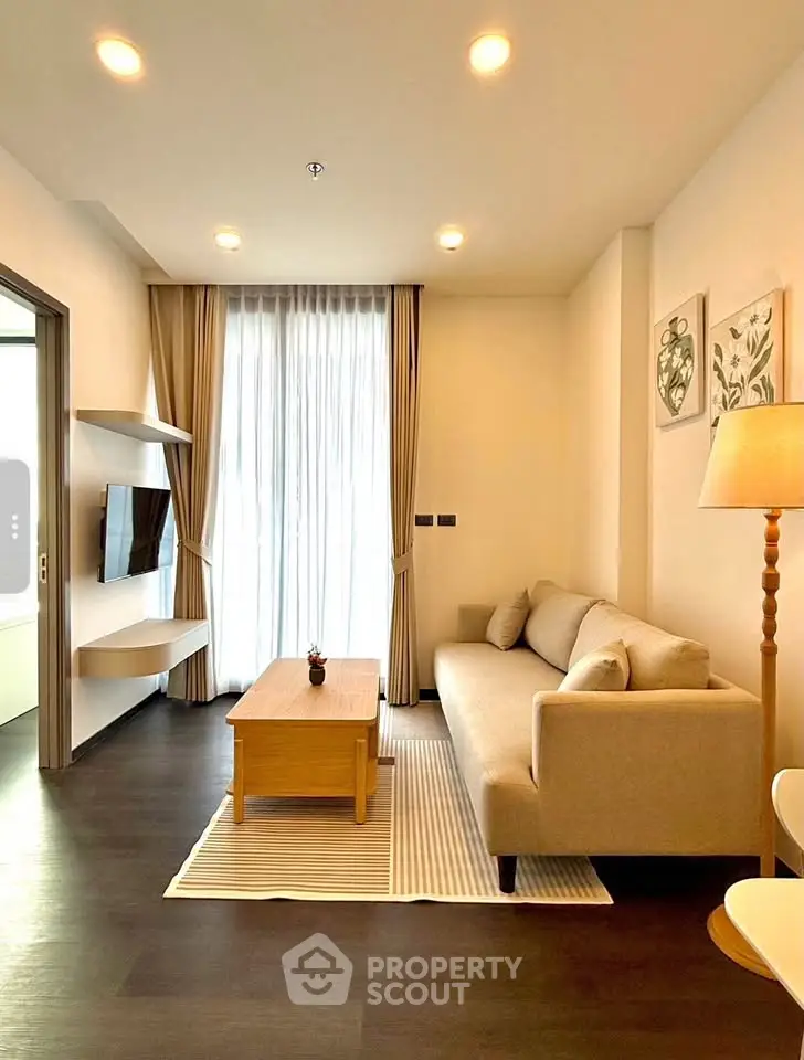 Modern living room with cozy sofa, wall-mounted TV, and elegant decor in a bright apartment.