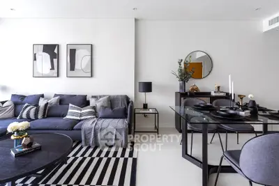 Modern living room with stylish decor, featuring a cozy sofa, elegant dining set, and contemporary artwork.