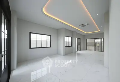 Spacious modern living room with elegant ceiling design and large windows