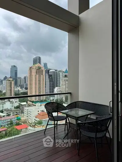 Stunning cityscape view from a modern balcony with elegant outdoor seating.