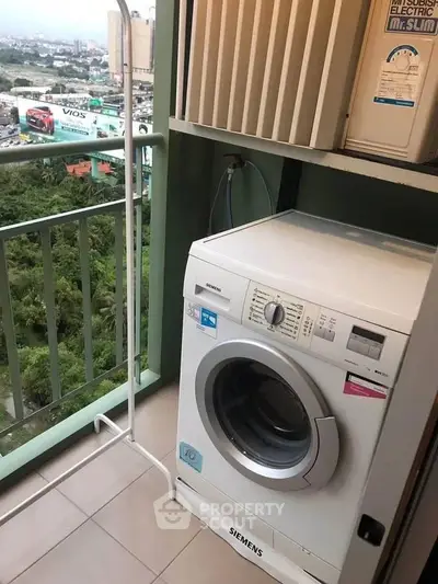 Compact balcony with washing machine and city view, perfect for urban living convenience.