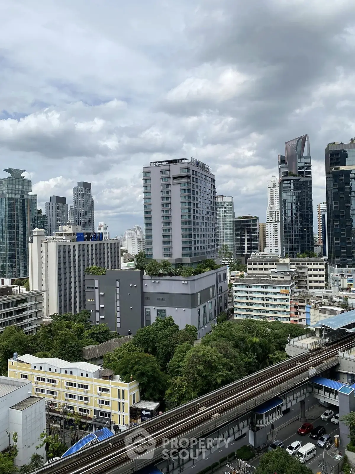 Stunning cityscape view showcasing modern high-rise buildings and lush greenery, perfect for urban living.