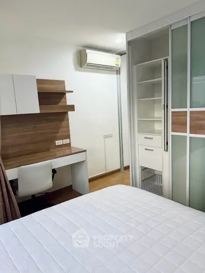Modern bedroom with built-in storage and workspace, featuring sleek design and ample natural light.