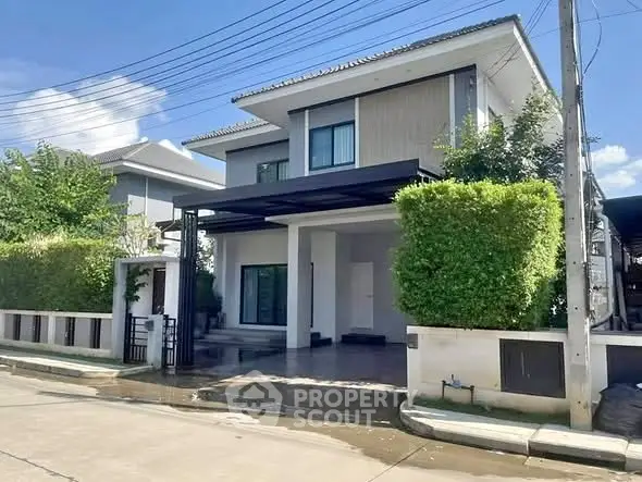 Modern two-story house with lush greenery and spacious driveway