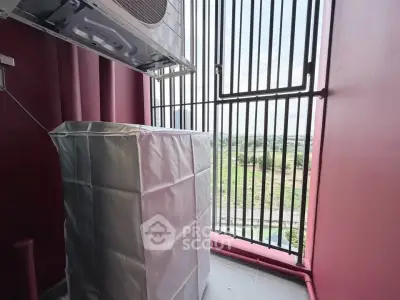 Compact balcony with air conditioning unit and protective cover, offering a view of the surrounding landscape.