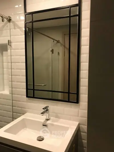 Modern bathroom with sleek mirror and stylish sink in contemporary design.