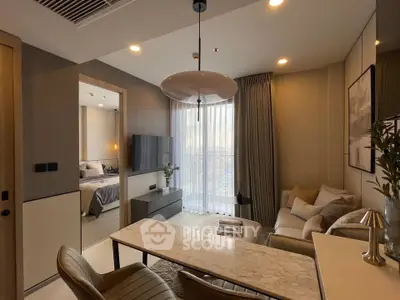 Modern living room with elegant decor and open view to bedroom, featuring cozy seating and stylish lighting.