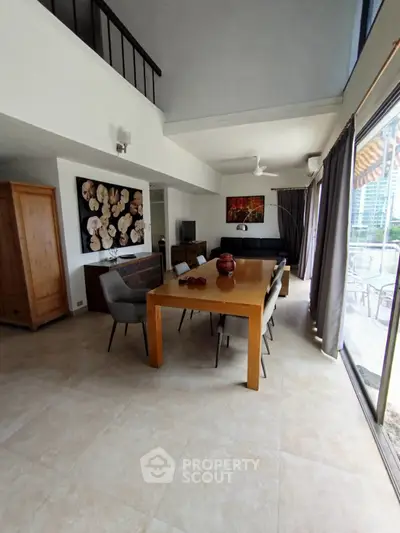 Spacious modern living room with high ceilings and large windows offering city views.