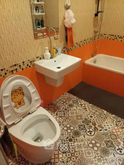 Charming bathroom with vibrant tiles and playful decor, featuring a bathtub and modern sink.