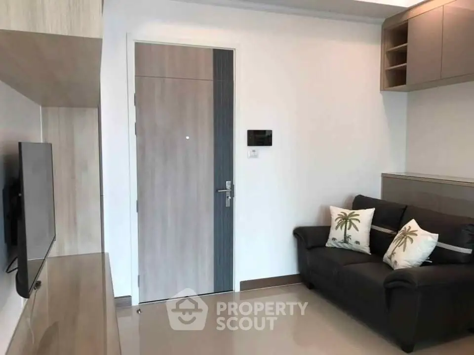 Modern living room with sleek design and cozy sofa, featuring a wall-mounted TV and stylish decor.