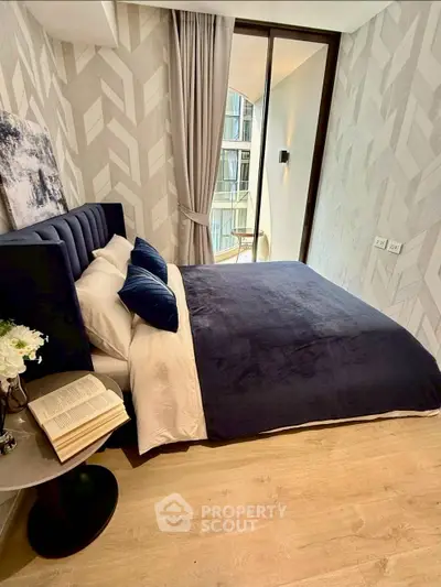 Modern bedroom with stylish decor and large window offering natural light.