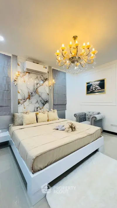 Luxurious bedroom with elegant chandelier and marble accent wall