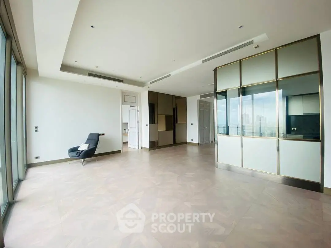 Spacious modern living room with floor-to-ceiling windows and sleek design in a luxury apartment.